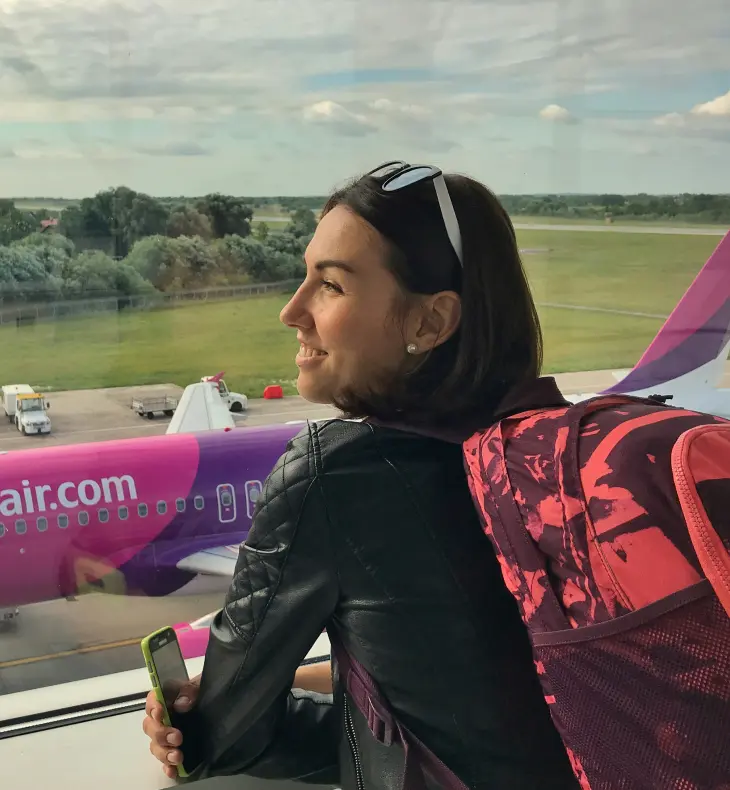 A traveller with a backpack looking out over an airport