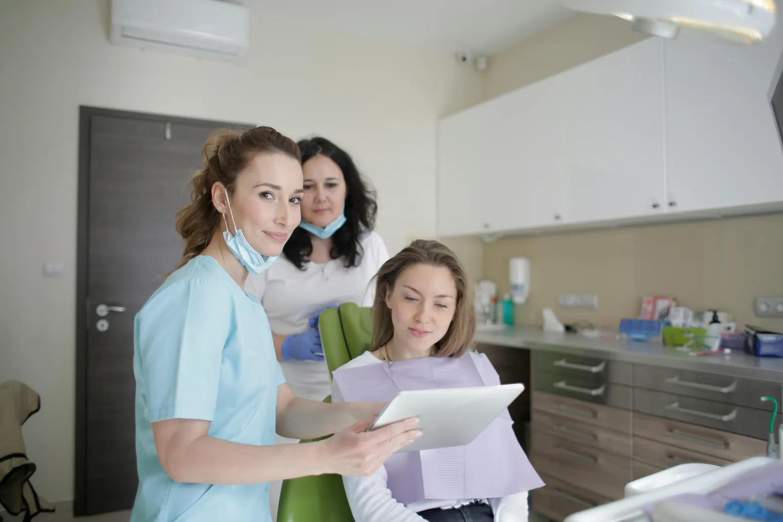 A dental team showing a treatment plan to a patient on a tablet