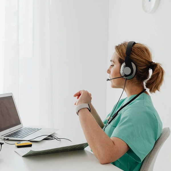 A SmileNow support agent with a headset at a laptop