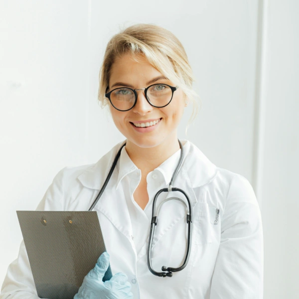A smiling doctor holding a clipboard